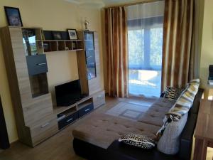 a living room with a couch and a television at Villa Persik in Utjeha
