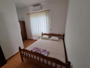 a small bedroom with a bed and a window at Roan Apartments in Velipojë