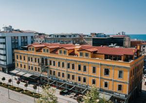 een oranje gebouw met een rood dak in een stadsstraat bij TS Park Hotel in Trabzon