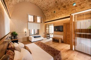 a bedroom with a large bed and a living room at Domus Renier Boutique Hotel - Historic Hotels Worldwide in Chania