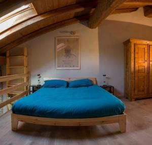 a bedroom with a large bed with blue sheets at AlfaBaita in Sampeyre