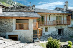 a house with a deck on the side of it at AlfaBaita in Sampeyre