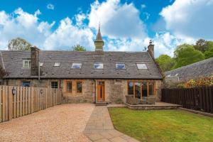 an old stone house with a wooden fence at Fantastic Cottage in Loch Lomond National Park in Alexandria