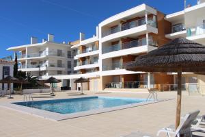 a hotel with a swimming pool and an umbrella at Ocean and pool in Olhos de Água