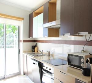 a kitchen with a microwave and a sink at Ocean and pool in Olhos de Água