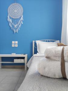 a blue bedroom with a bed and a blue wall at Poseidon Rooms in Kala Nera