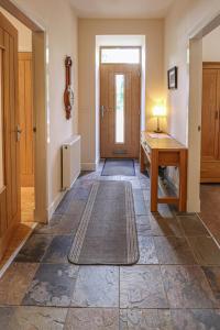 korytarz z drzwiami, stołem i dywanem w obiekcie Fantastic Cottage in Loch Lomond National Park w mieście Alexandria