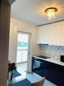 a kitchen with a window and a table with chairs at Dina Lux Iasi Apartment in Iaşi