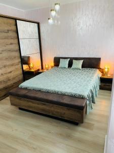 een slaapkamer met een bed, 2 tafels en een raam bij Dina Lux Iasi Apartment in Iaşi