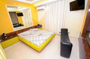 Dormitorio pequeño con cama y espejo en Hotel Premier (Adult Only), en Nilópolis