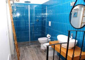 y baño de azulejos azules con aseo y ducha. en B&B Nonno Carmine, en Pompeya