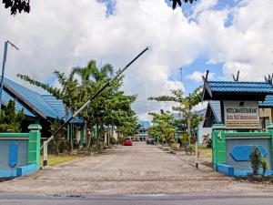 a street in a small town with a car driving down the road at Capital O 90417 Hotel Batu Suli Internasional in Palangkaraya