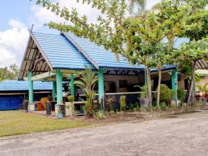 una casa con techo azul y algunos árboles en Capital O 90417 Hotel Batu Suli Internasional en Palangkaraya