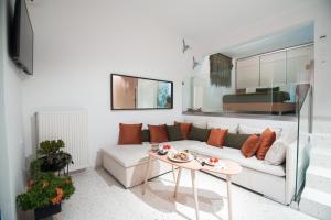 a living room with a white couch and a table at Anemos Seaside Apartment in Neos Marmaras
