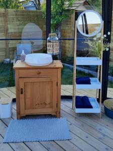 ein Waschbecken und ein Stuhl auf einer Terrasse in der Unterkunft Au Clair de ma Bulle in Marche-en-Famenne