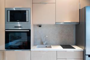 a kitchen with a microwave and a sink at Anemos Seaside Apartment in Neos Marmaras