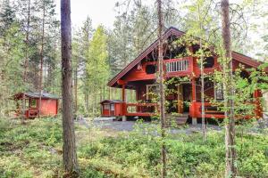 eine rote Hütte im Wald mit Bäumen in der Unterkunft Kuhahuvila, Kalajärvi, Maatilamatkailu Ilomäen mökit in Peräseinäjoki