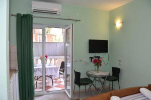 a living room with a table and chairs and a sliding glass door at Beachfront - Vali in Tkon