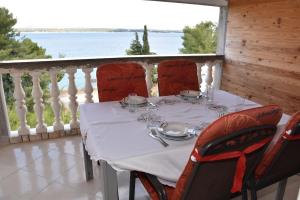 a table on a balcony with a view of the water at Beachfront - Vali in Tkon