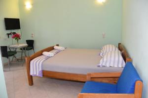 a bedroom with a bed and a blue chair at Beachfront - Vali in Tkon