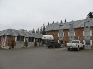 ein Gebäude mit einem LKW, der davor parkt in der Unterkunft Twin Pine Inn & Suites in Hinton