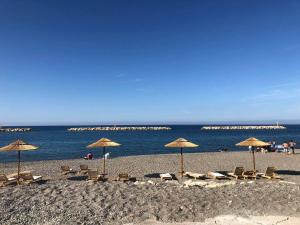 a group of chairs and umbrellas on a beach at Angel-kolymvari4you in Kolymvari
