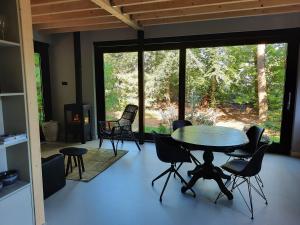 a dining room with a table and chairs and a fireplace at Het Uilennest in Otterlo