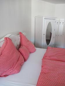 a white bed with pink pillows and a mirror at Villa Rosali Boutique Hotel in Hamburg