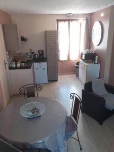 a living room with a table and a kitchen at ENFIN ! in Grandcamp-Maisy