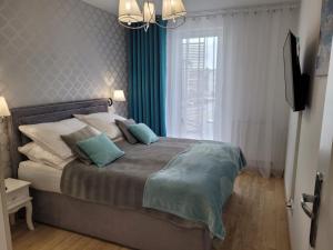 een slaapkamer met een groot bed met blauwe accenten bij Sunset II in Dziwnówek