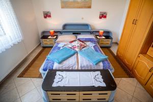 een kleine slaapkamer met een bed met twee dressoirs bij Apartments Fuma in Otočac