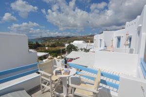 a balcony with chairs and a table on a building at ThalaSEA - village Antiparos in Antiparos