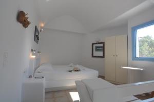 a white room with a bed and a window at ThalaSEA - village Antiparos in Antiparos