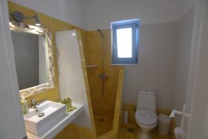 a bathroom with a sink and a toilet and a mirror at ThalaSEA - village Antiparos in Antiparos