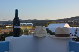 two hats and two glasses of wine on a table at ThalaSEA - village Antiparos in Antiparos