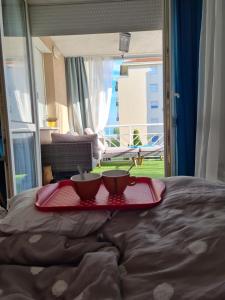 two cups on a tray on top of a bed at EDA Beach Apartman in Siófok