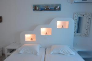 a bedroom with two beds with lights on the wall at ThalaSEA - village Antiparos in Antiparos