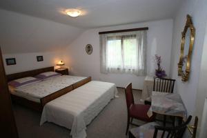 una camera da letto con due letti, un tavolo e una finestra di Villa Lindwurm a Klagenfurt