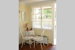 una sala da pranzo con tavolo, sedie e una finestra di Villa Lindwurm a Klagenfurt