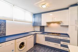 a kitchen with white cabinets and a washer and dryer at ¡Nuevo! Playa de Sardinero con espectaculares vistas in Santander