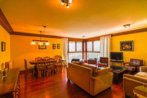 a living room with a couch and a dining room at ¡Nuevo! Playa de Sardinero con espectaculares vistas in Santander