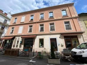 a building with tables and chairs in front of it at MRTN APARTMENTS Studio & Suites - Aix-les-Bains, hypercentre in Aix-les-Bains