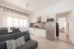 salon z szarą kanapą i kuchnią w obiekcie EasyStayRome Vatican Home Free WiFi Metro w Rzymie