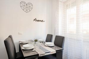 jadalnia ze stołem z krzesłami i sercem na ścianie w obiekcie EasyStayRome Vatican Home Free WiFi Metro w Rzymie +1 zdjęcie