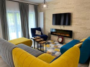 a living room with a yellow couch and a fireplace at Casa Skadi, Zamora,Busteni in Buşteni