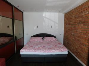 a bed in a room with a brick wall at Apartmánový Penzión Bojnice in Bojnice