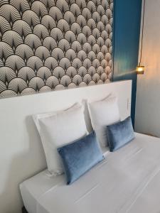 un letto con due cuscini blu sopra di Les Terrasses de Sari a Sari Solenzara