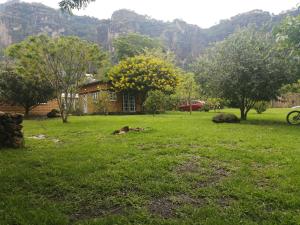 een huis in een grasveld met bergen op de achtergrond bij Posada Meztitla in Tepoztlán