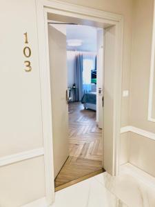 eine Tür, die in ein Wohnzimmer mit einem Spiegel führt in der Unterkunft Luxury Apartments in Residence Maritime in Misdroy