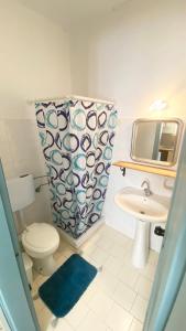 ein Badezimmer mit Toilette, Waschbecken und Spiegel in der Unterkunft Egli in Stalós + 38 Fotos